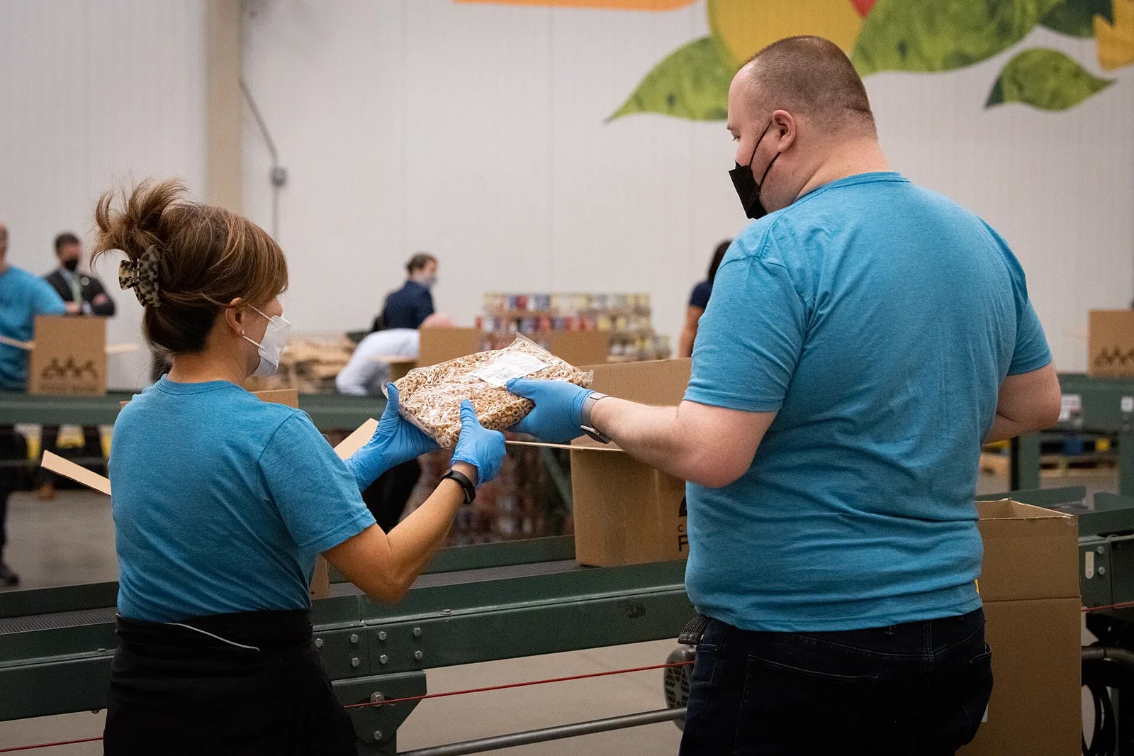 Volunteers packing boxes of groceries at a community food bank