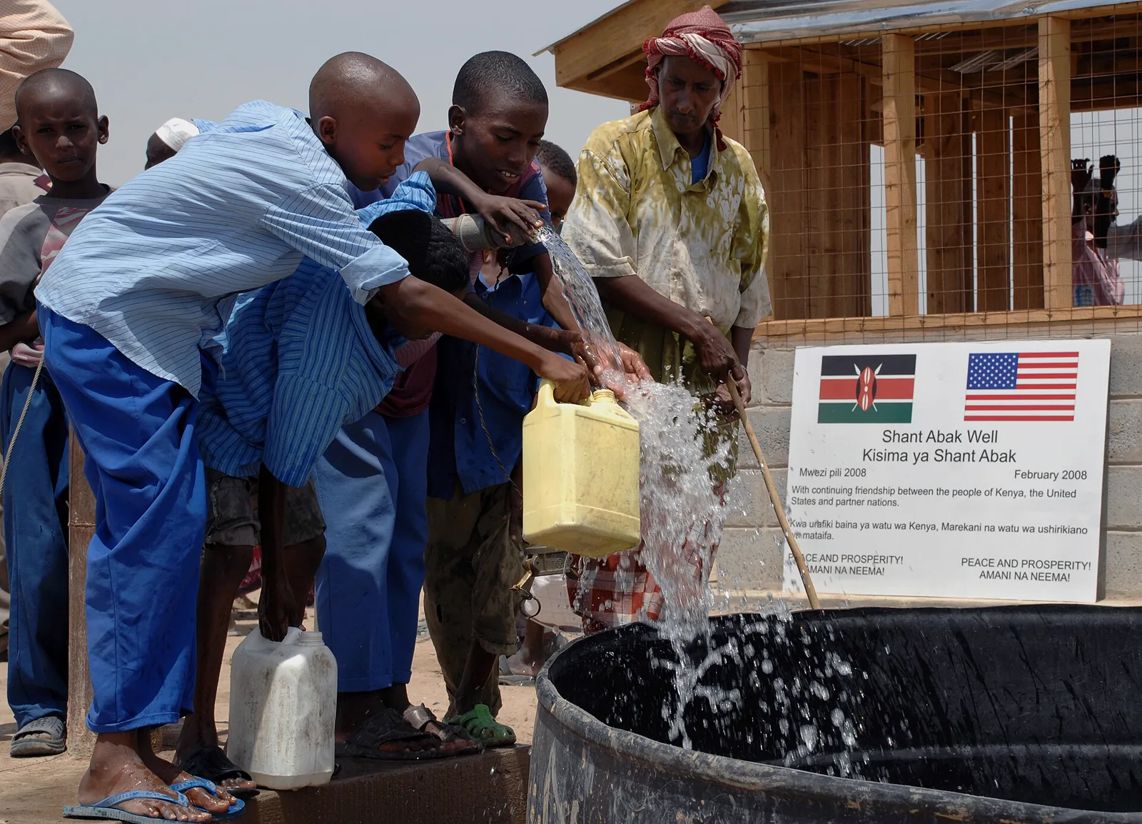 Community members collecting clean drinking water at a village pump