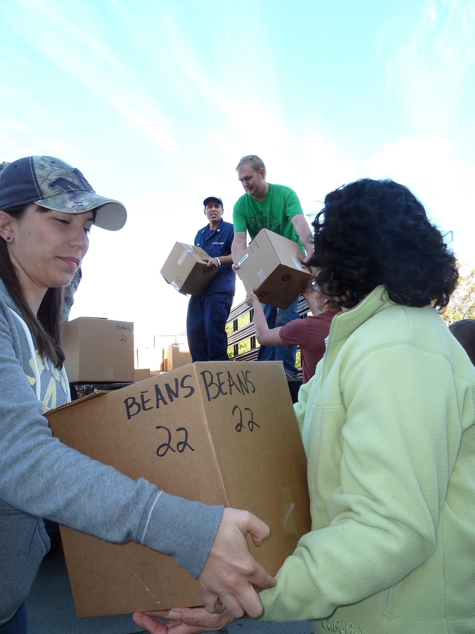 Volunteers helping neighbours collect groceries at a community distribution