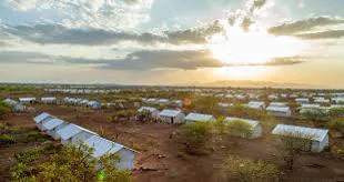 Aid convoy and shelter tents in an arid displacement site in Sudan